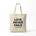 Tote bag beige Love Never Fails avec verset 1 Corinthiens 13:8